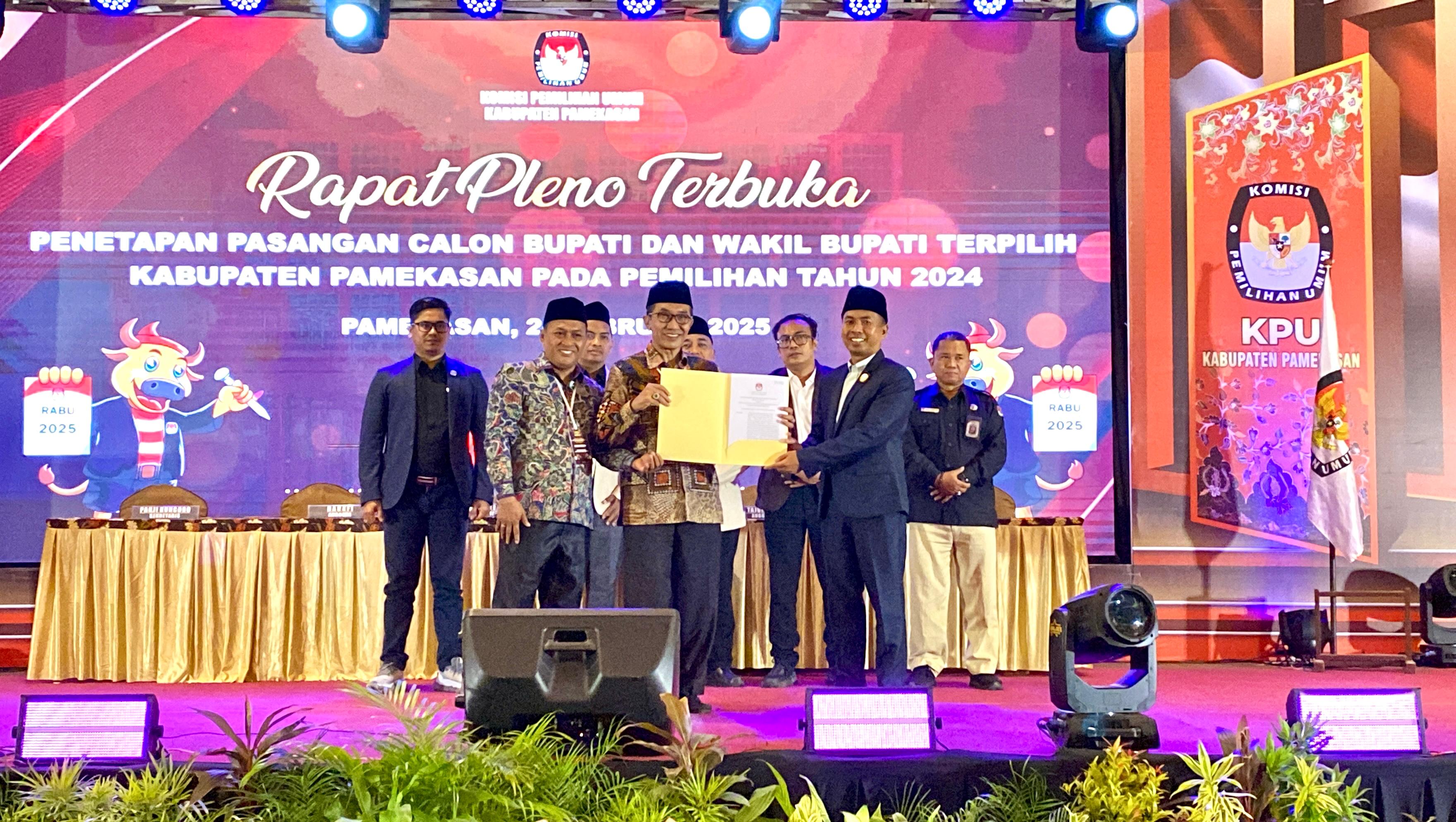 HASIL PLENO: Ketua KPU Pamekasan Mahdi menyerahkan SK kepada Bupati Terpilih Pamekasan KH Kholilurrahman di Hotel Odaita, Rabu (26/2) malam. (FAHMI JALIL/JPRM)