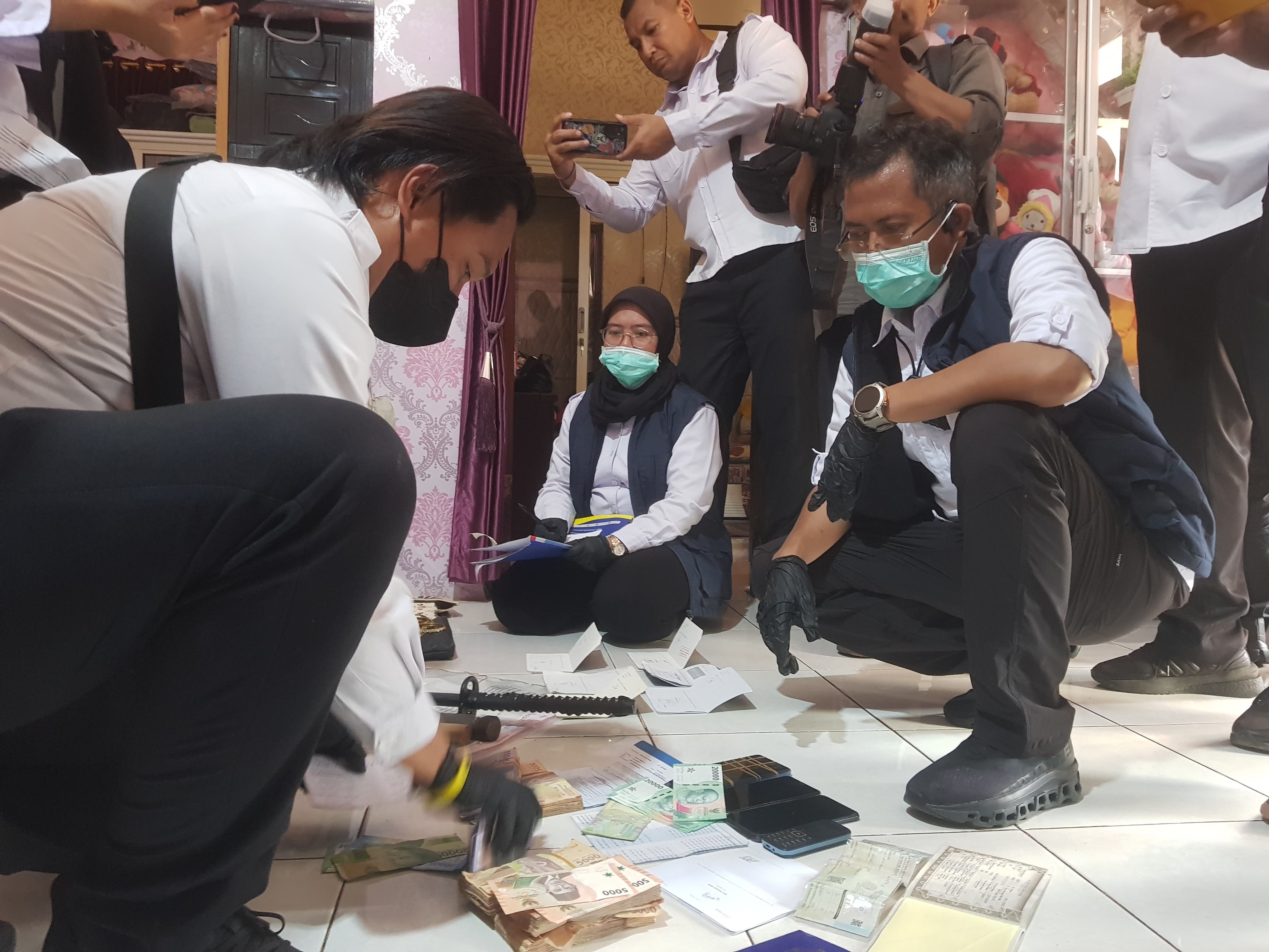 UPAYA HUKUM: Petugas BNNP Jatim mengumpulkan barang bukti di salah satu rumah DPO di Desa Parseh, Kecamatan Socah, Bangkalan, Senin (3/3). (ZEINAL ABIDIN/JPRM)