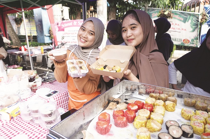 JAJANAN KEKINIAN: Asri Agustina Salsabila saat menjajakan jualannya di Bazar Takjil Ramadan Bangkalan, Sabtu (1/2). (VIVIN AGUSTIN HARTONO/JPRM)