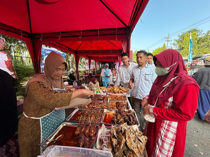 LARIS MANIS: Sumiyah melayani pembeli di bazar takjil Ramadan, Selasa (4/3). (VIVIN AGUSTIN HARTONO/JPRM)