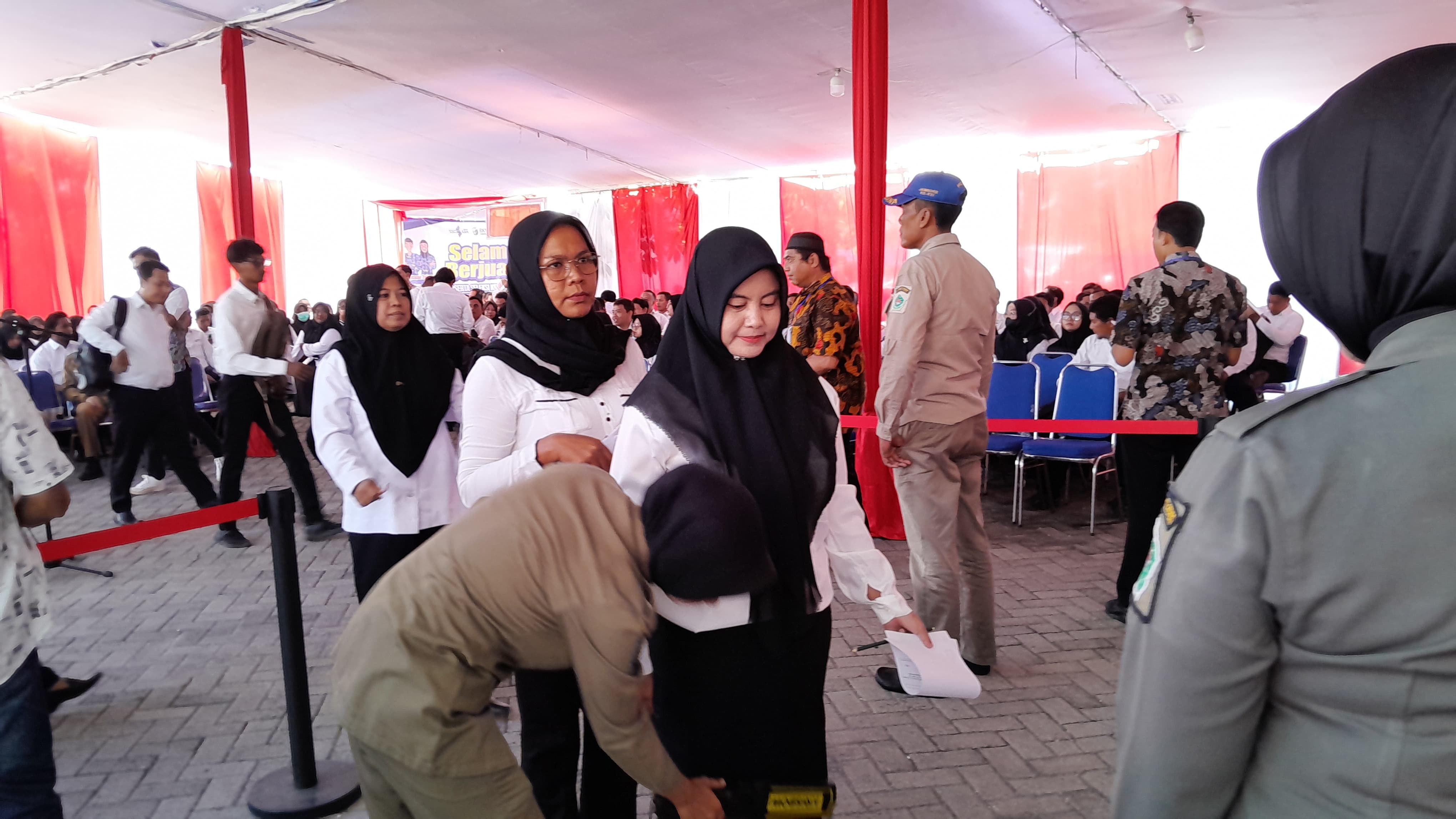 TERTIB: Peserta seleksi PPPK 2024 tahap satu diperiksa sebelum mengikuti tes kompetensi di Gedung Prima Jaya Abadi, Pamekasan, Selasa (3/12/2024). (M. KHOLIL RAMLI/JPRM)