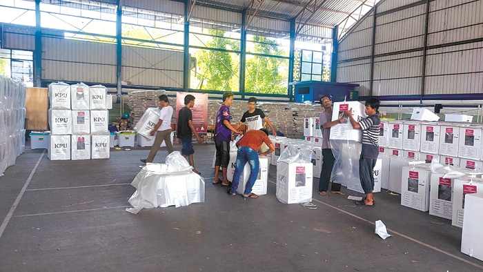 TIDAK BOLEH RUSAK: Sejumlah pekerja sedang menyiapkan logistik yang disimpan di GOR Indoor Sampang, Rabu (20/11/2024). (JUNAIDI PONDIYANTO/JPRM)