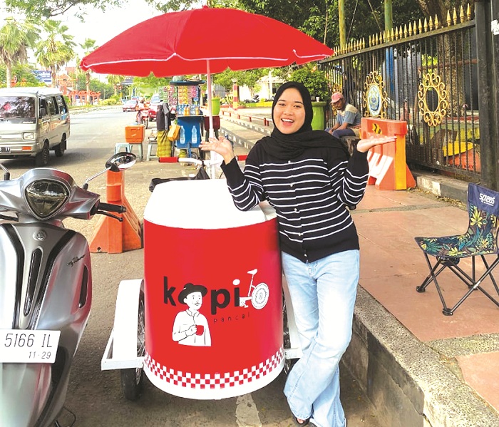 MENJANJIKAN: Asra Agustini Salsabila saat berjualan kopi pancal di Alun-Alun Bangkalan, Minggu (9/2). (ASRA AGUSTINI SALSABILA UNTUK JPRM)