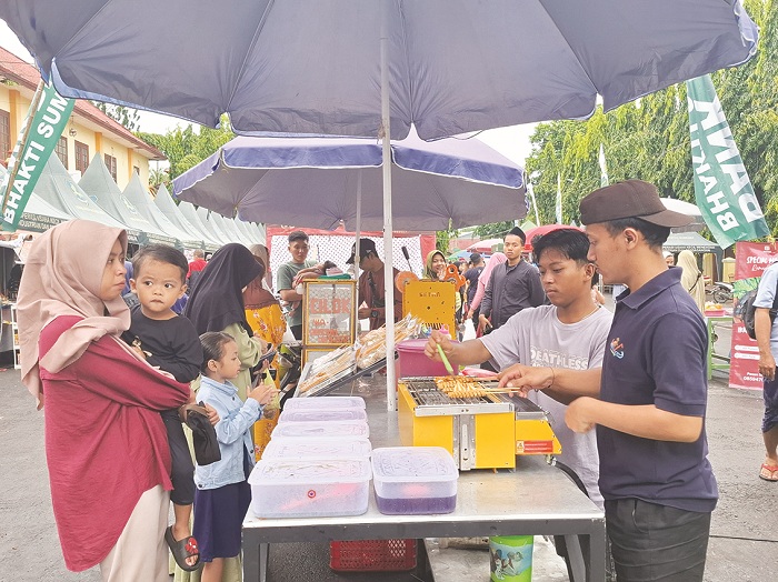 BERNIAGA: Abrori sedang melayani pembeli di festival bazar takjil Ramadan di Jalan dr Soetomo, Kelurahan Pajagalan, Kecamatan Kota Sumenep, Minggu (9/3). (MOH. LATIF/JPRM)
