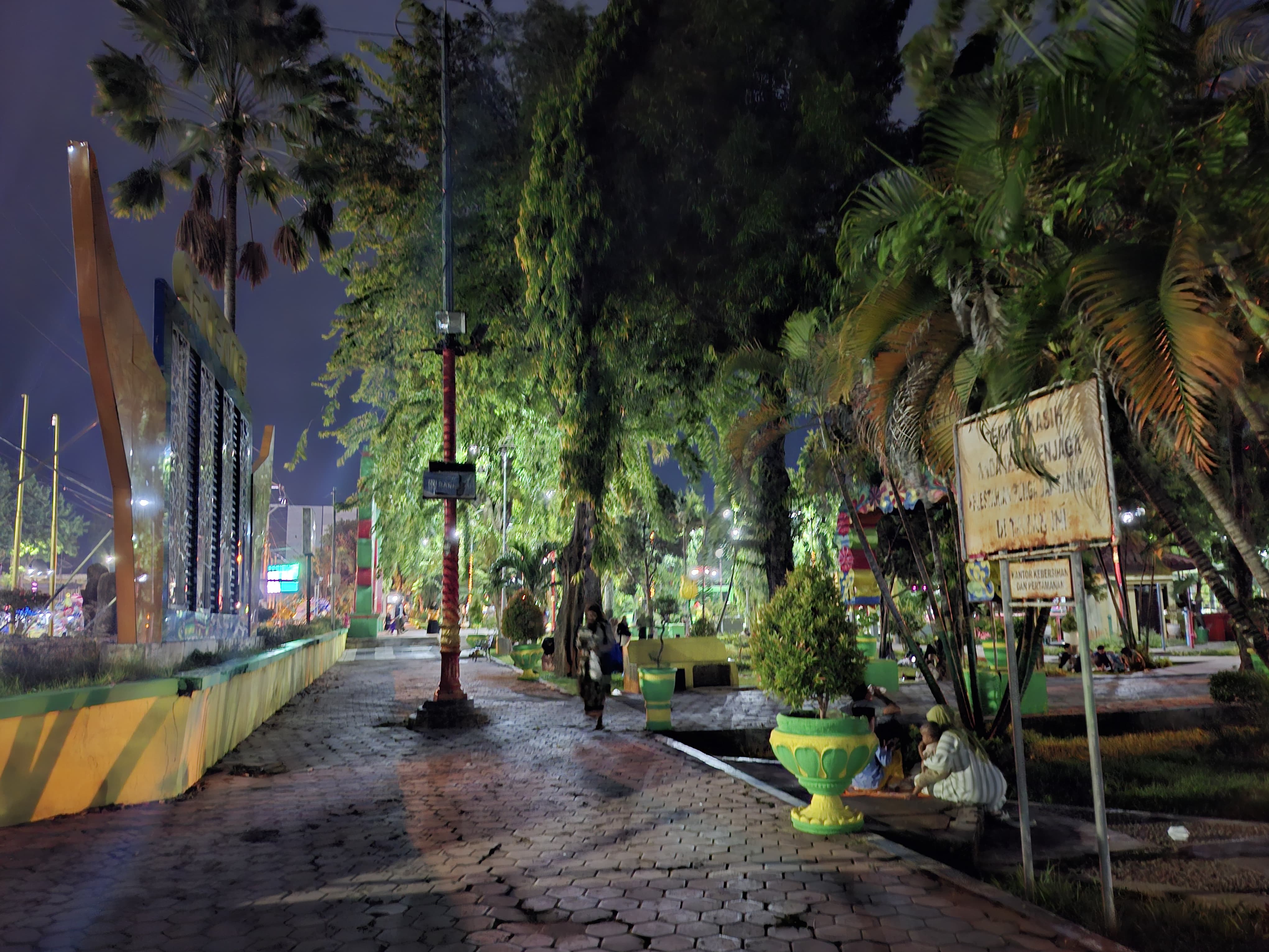 BUTUH PERBAIKAN: Warga buka bersama di sekitar lampu Taman Bunga Pottre Koneng yang padam, Jumat (7/3). (MOH. IQBAL/JPRM)
