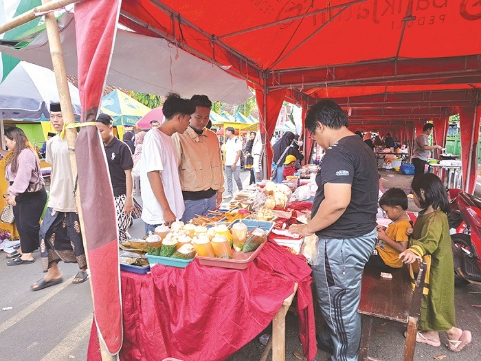 LAKU: Sugeng Agung Pratama menjaga barang dagangannya di Festival Bazar Takjil Ramadan, Jalan dr. Soetomo, Kelurahan Pajagalan, Kecamatan Kota Sumenep, Selasa (11/3). (MOH. LATIF/JPRM)
