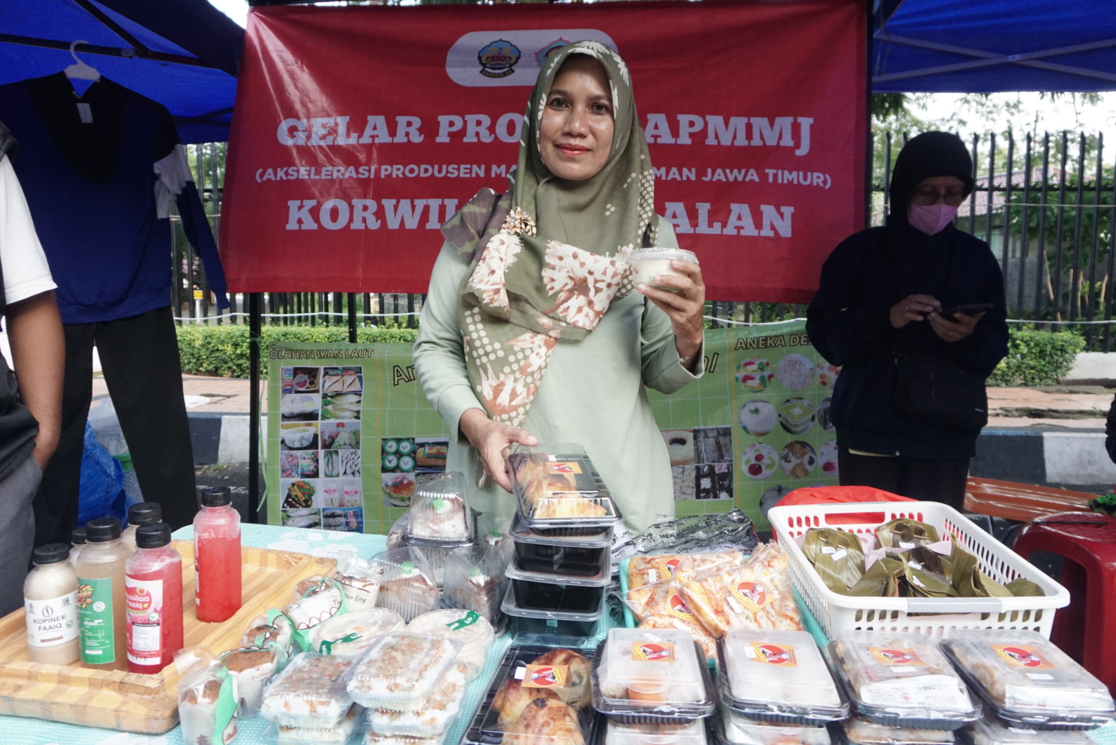LARIS MANIS: Rita Ningsih tengah menjajakan berbagai macam produk IKM di stannya di area Bazar Takjil Ramadan Bangkalan, Senin (10/3). (VIVIN AGUSTIN HARTONO/JPRM)