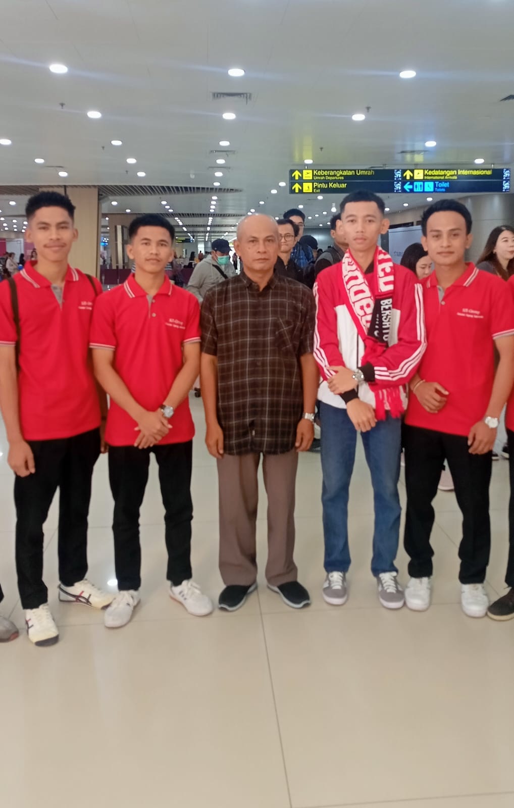 BERPRESTASI: Kepala SMKS Mambaul Ulum Bata-Bata Muniriyanto (tengah) berfoto bersama siswanya di Bandara Internasional Juanda, Selasa (11/3). (SMKS MUBA UNTUK JPRM)
