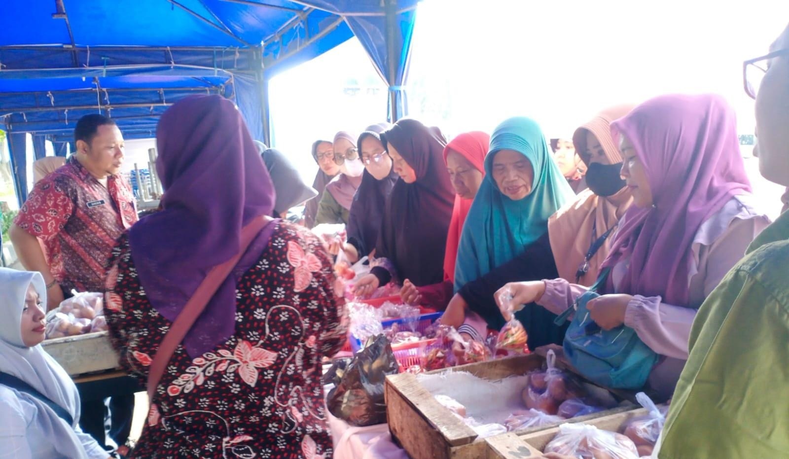KEBUTUHAN BAHAN POKOK: Sejumlah warga membeli kebutuhan bahan pokok di kegiatan pangan murah di Jalan Letnan Abdullah, Bangkalan, Jumat (14/3). (BAMBANG MUSTIKA UNTUK JPRM)