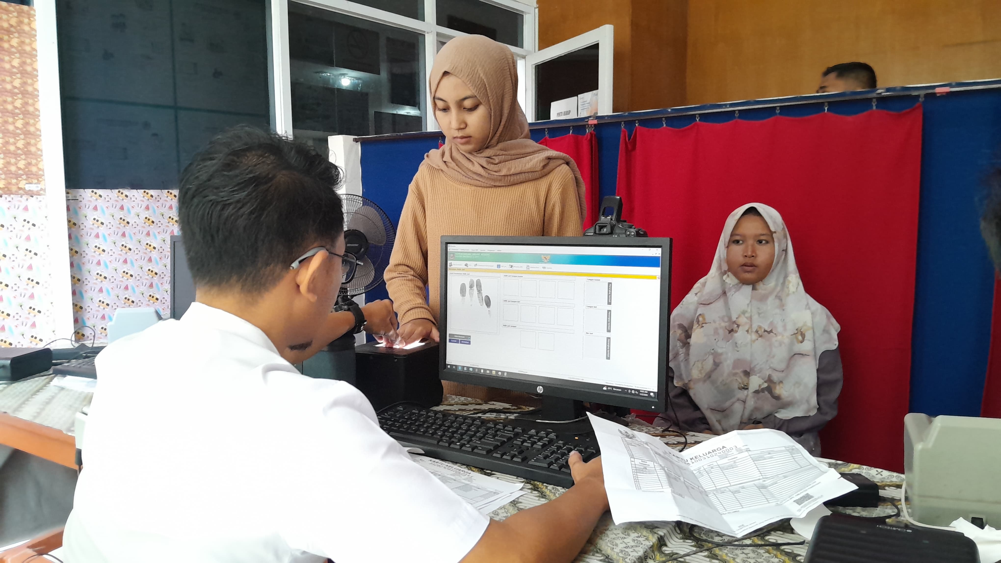 MELAYANI: Warga sedang melakukan perekaman identitas kependudukan di kantor Dispendukcapil Pamekasan, Rabu (22/1). (KHOLIL RAMLI/JPRM)