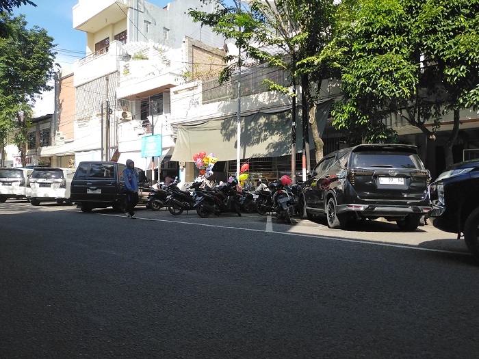 LENGANG: Jukir di Jalan Panglima Sudirman, Bangkalan, mengawal kendaraan, Selasa (11/3). (VIVIN AGUSTIN HARTONO/JPRM)