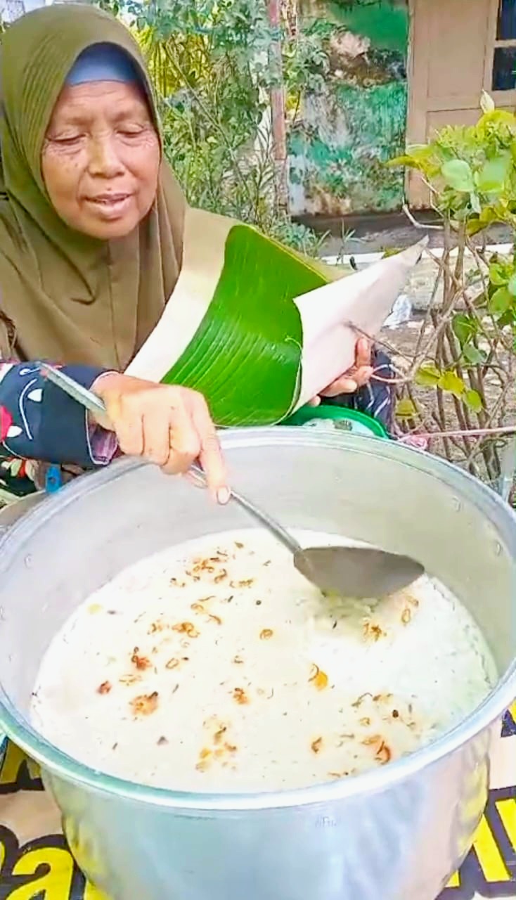 Suniah hendak membungkus tajin lemak pesanan pembeli dengan daun pisang.
