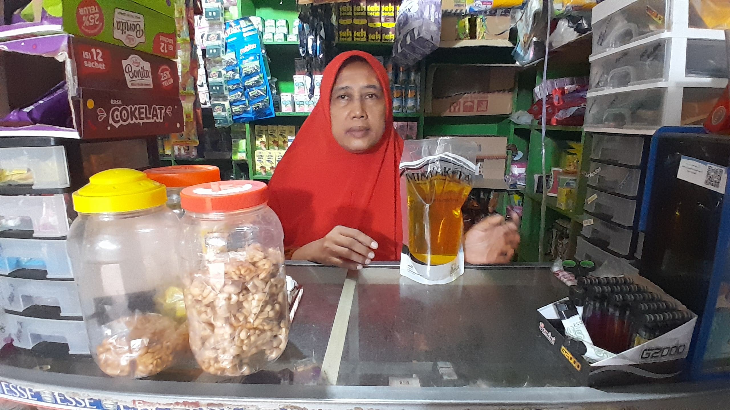 DPRD JANJI SIDAK PASAR: Seorang pedagang di Jalan Kabupaten, Pamekasan, menunjukkan migor Minyakita yang dijualnya Minggu (16/3). (M. KHOLIL RAMLI/JPRM)