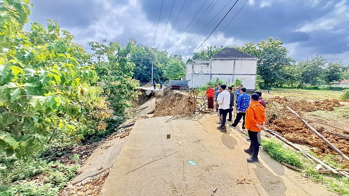 RUSAK PARAH: Tim BPBD Sampang dan DPUPR Sampang mengecek lokasi jalan kabupaten yang lonsor di Desa Gunung Eleh, Kecamatan Kedungdung, Sampang, kemarin. (BPBD UNTUK JPRM)