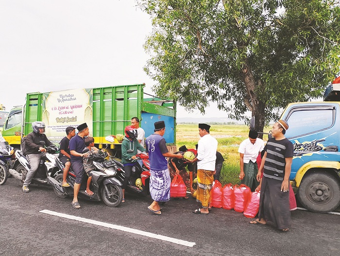 BERKAH RAMADAN: UD Zainal Abidin (Garam) Sampang berbagi takjil bersama kru truk Lolelo di Jalan Raya Gulbung II, Gulbung, Pangarengan, Rabu (19/3). (UBAIDILLAHIR RAIE/JPRM)