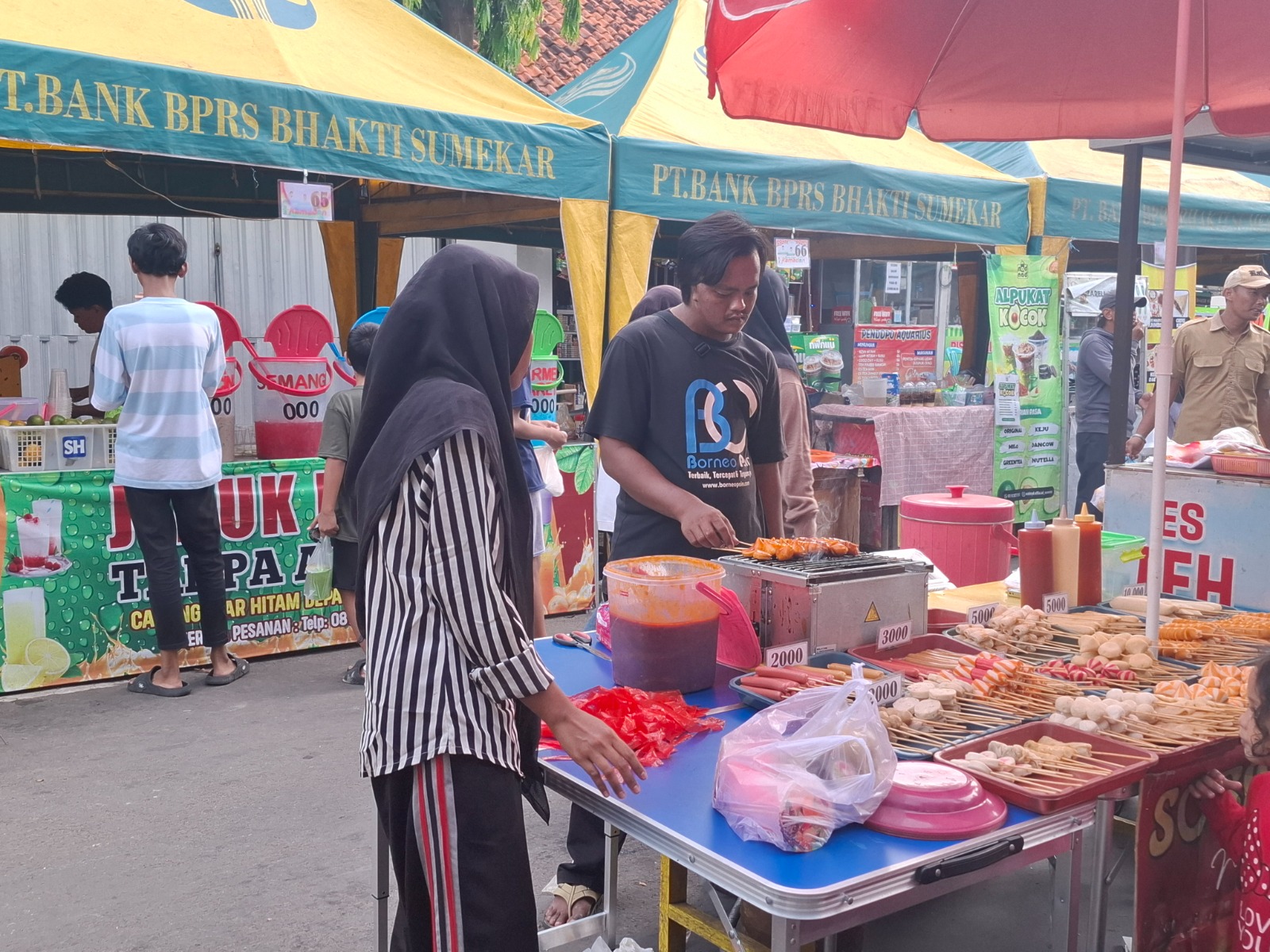 LARIS: Anwari sedang melayani pembeli di Festival Bazar Takjil Ramadan, Jalan dr Soetomo, Kelurahan Pajagalan, Kecamatan Kota Sumenep, Selasa (18/3). (MOH. LATIF/JPRM)