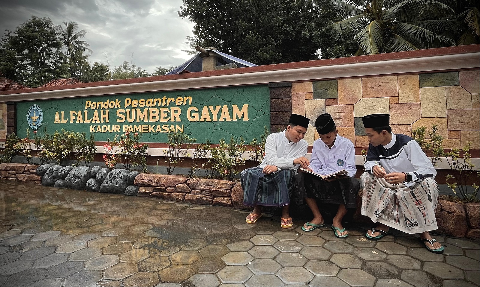 SANTAI: Santri membaca kitab di area Masjid Ponpes Al-Falah Sumber Gayam, Kadur, Pamekasan, Senin (10/3). (MOH. IQBAL AFGANI/JPRM)