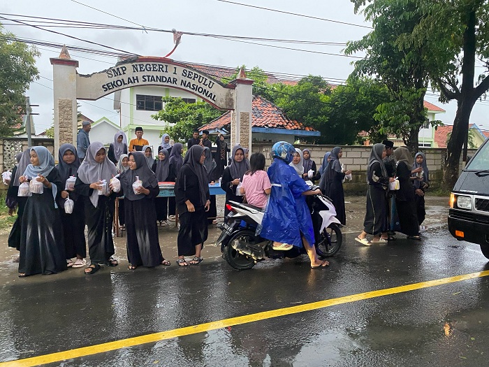 SUASANA RAMADAN: Siswa bersama guru SMPN 1 Sepulu berbagi takjil gratis di Jalan Raya Sepulu, Bangkalan, Kamis (20/3). (SMPN 1 SEPULU UNTUK JPRM)