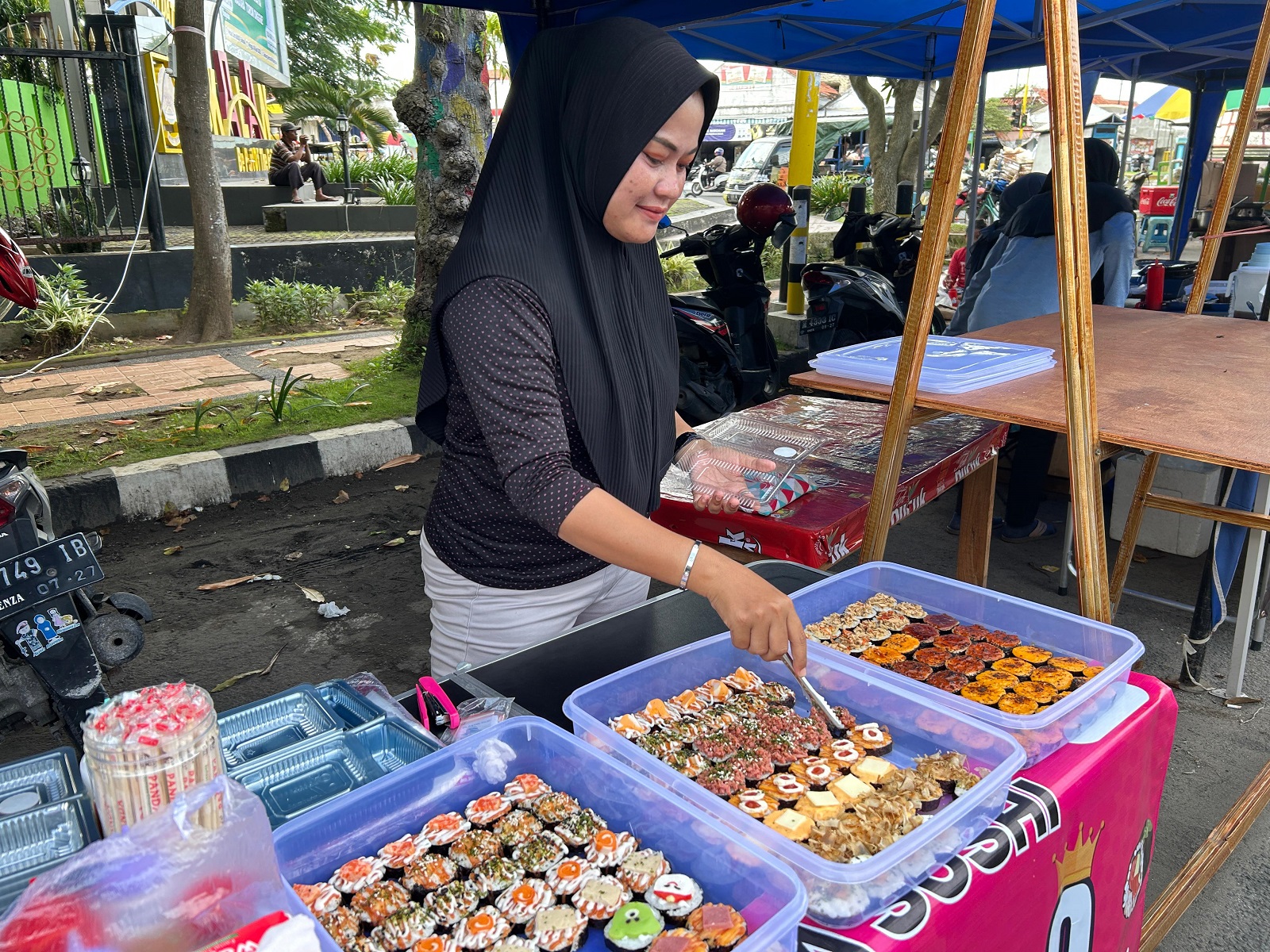 BANYAK VARIAN: Salah seorang pelaku usaha Nisayus Syahidiyah menjual sushi di area Bazar Takjil Ramadan di Alun-Alun Bangkalan, Selasa (18/3). (VIVIN AGUSTIN HARTONO/JPRM)