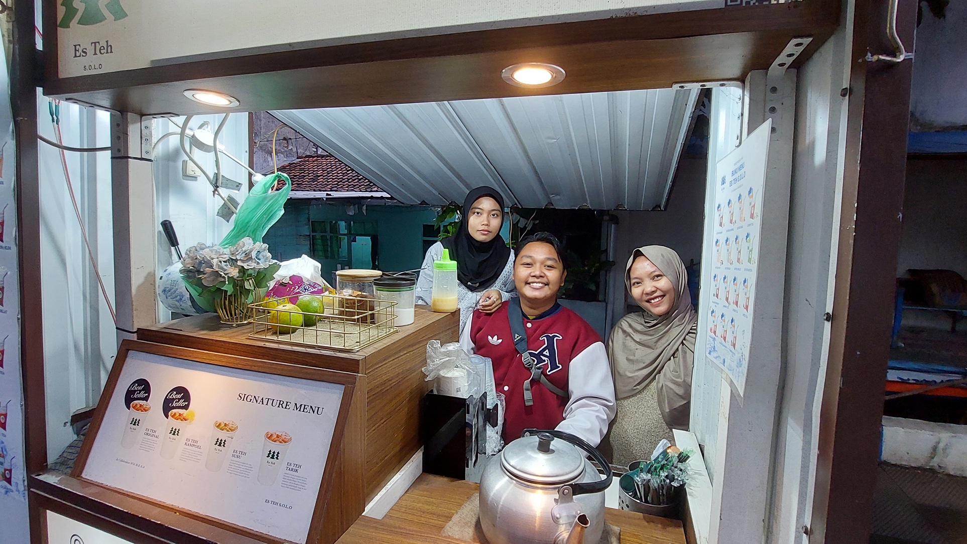 PRODUKTIF: Pemilik Teh Solo Adhitya Lukiswara Madiasta Warman (pakai jaket) bersama dua sahabatnya ketika menjaga lapaknya di Jalan KH Wahid Hasyim, Kota Sampang, kemarin. (JUNAIDI PONDIYANTO/JPRM)