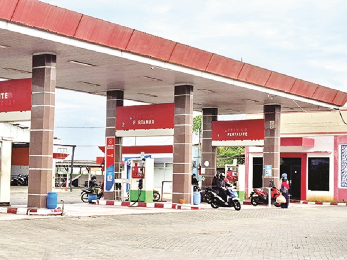 ANTRE: Pengendara sepeda motor mengisi BBM di SPBU Pertamina 54.694.08 yang merupakan salah satu unit usaha PT WUS di Jalan Arya Wiraraja, Gedungan, Batuan, Sumenep, Minggu (23/3). (MOH. LATIF/JPRM)