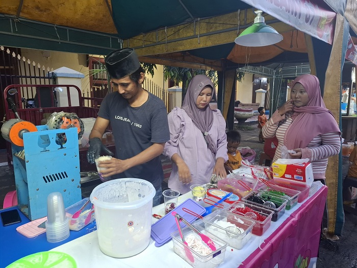 LAKU: Rahmani (tengah) melayani pembeli di Festival Bazar Takjil Ramadan di Jalan dr Soetomo, Kelurahan Pajagalan, Kecamatan Kota Sumenep, Rabu (26/3). (MOH. LATIF/JPRM)  &nbsp;