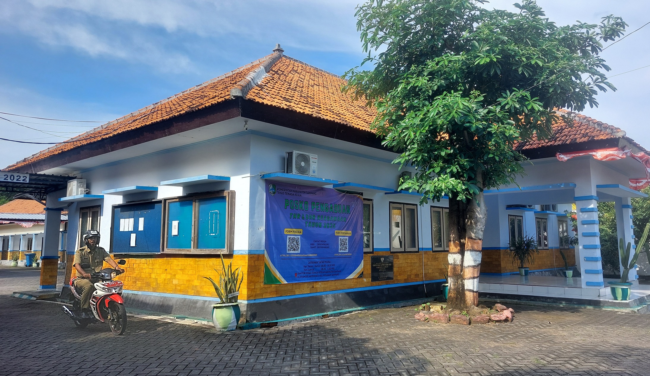 PUSAT LAYANAN: Pegawai melintas di sekitar gedung posko THR keagamaan di kantor Dinas Tenaga Kerja Sampang, Selasa (25/3). (JUNAIDI PONDIYANTO/JPRM)