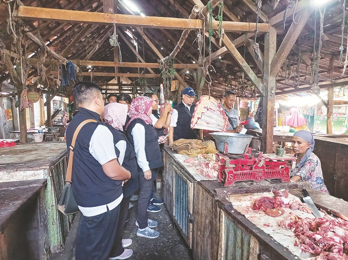 HARGA NAIK: Staf Disnak Bangkalan saat berdialog dengan pedagang daging yang ada di Pasar Tanah Merah, Rabu (19/3). (DISNAK UNTUK JPRM)