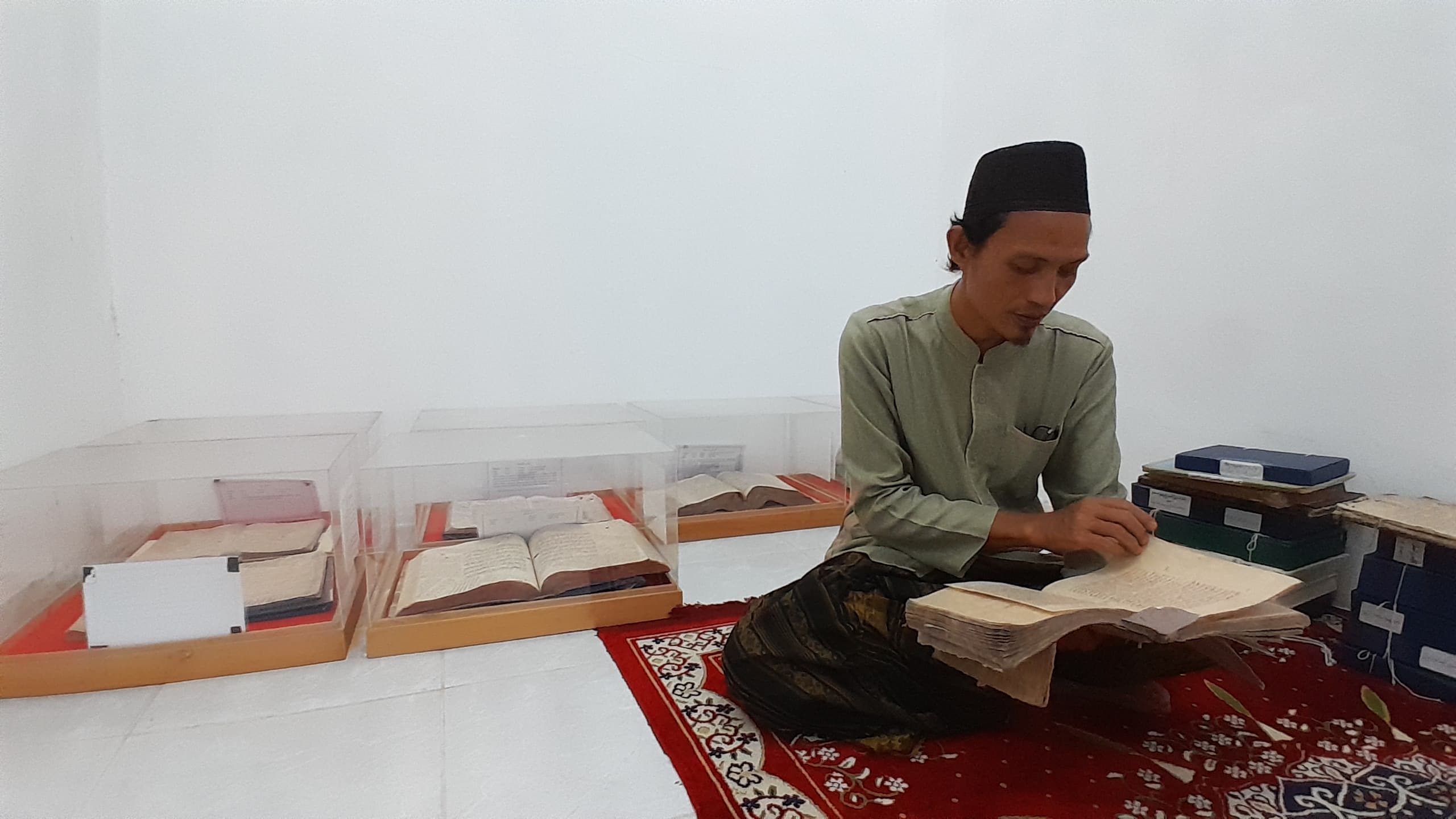 SAMUDRA ILMU: Pendiri Padepokan Raden Umro Ponpes Sumber Anyar Pamekasan Habibullah Bahwi menerangkan salah satu isi manuskrip koleksinya, Kamis (6/3). (M. KHOLIL RAMLI/JPRM)
