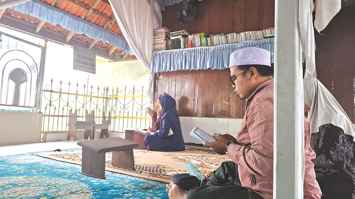 KHUSYUK: Peziarah membaca Al-Qur&rsquo;an di Makam Sunan Cendana di Desa Kwanyar, Kecamatan Kwanyar, Bangkalan, Jumat (28/3).&nbsp;(IMAMUDIN/JPRM)