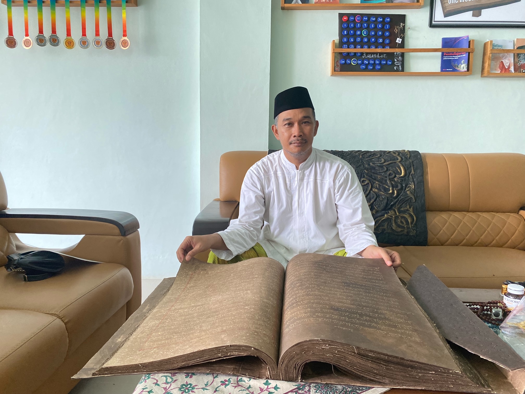TERAWAT: Achmad Muhlis membuka manuskrip Al-Qur&rsquo;an peninggalan Sunan Gunung Jati di IBS PKMKK, Kamis (20/3). (AYU LATIFAH/JPRM)