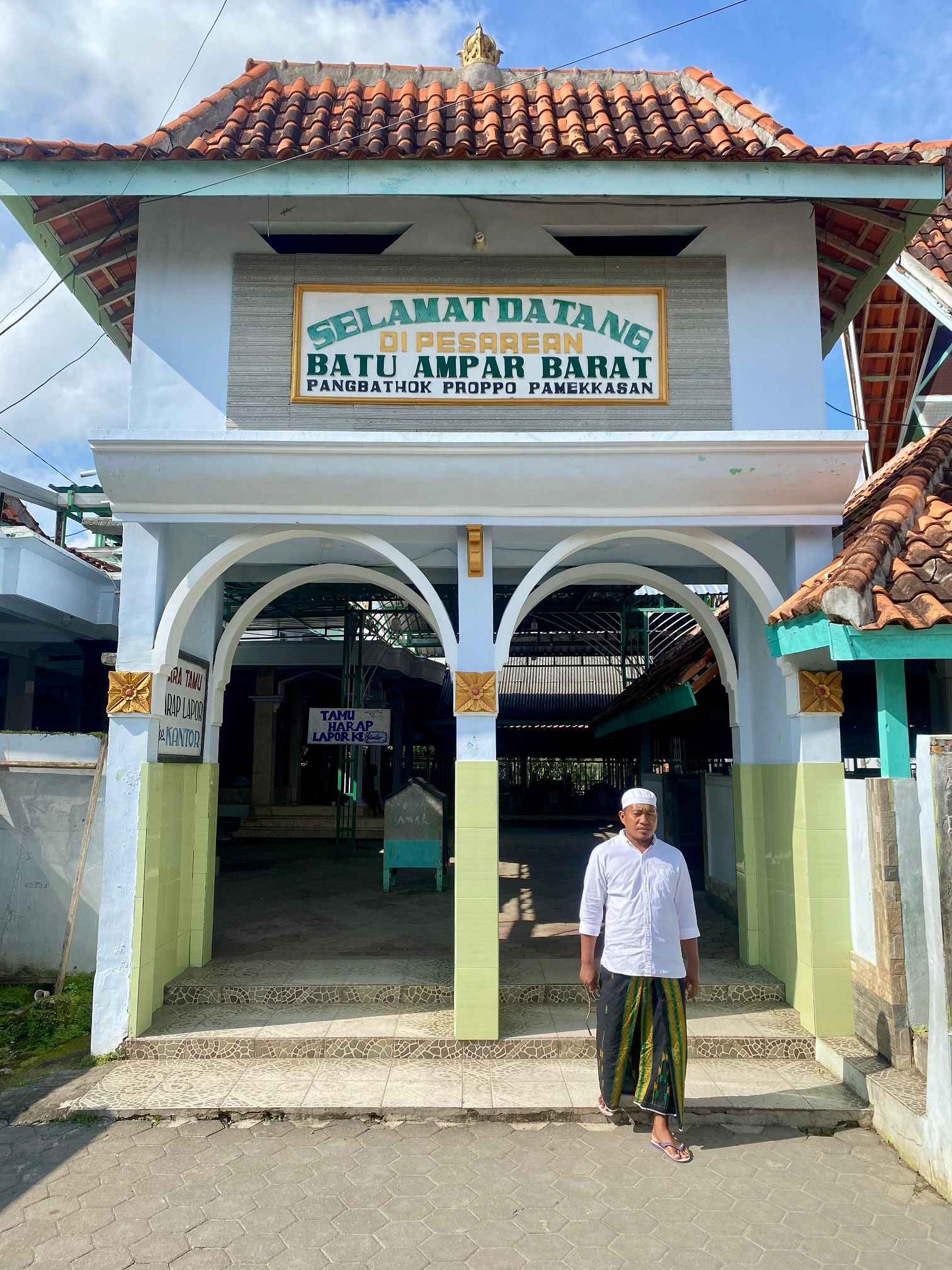 TERIK: Pengunjung keluar dari pintu masuk Yayasan Satu Pesarean Batu Ampar Barat di Desa Pangbatok, Kecamatan Proppo, Pamekasan, Jumat (28/3). (MOH. IQBAL AFGANI/JPRM )