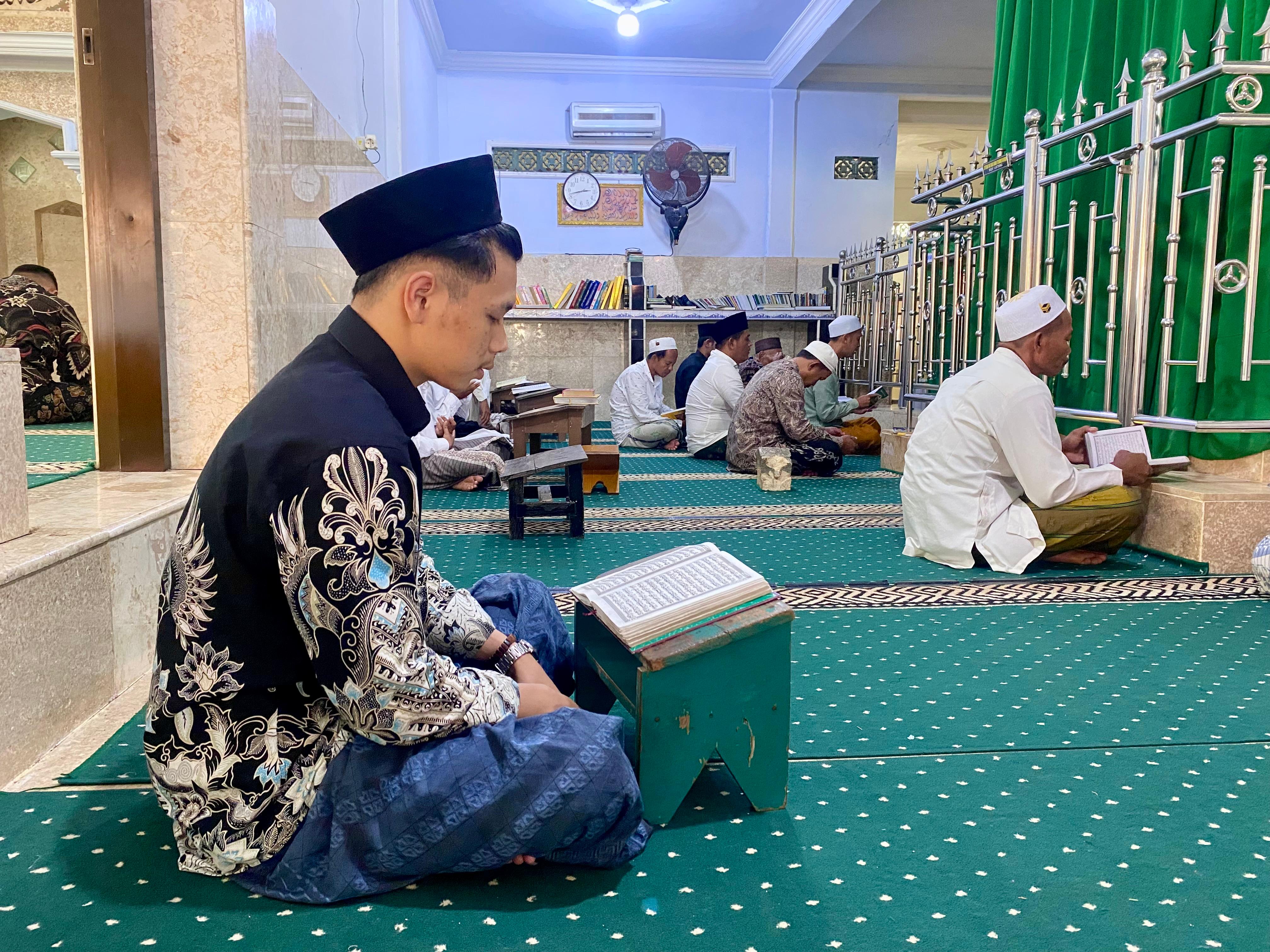 RUTIN: Achsin Maulana mengaji di Pesarean Batu Ampar Barat, Desa Pangbatok, Kecamatan Proppo, Pamekasan, Jumat (28/3). (MOH. IQBAL AFGANI/JPRM)