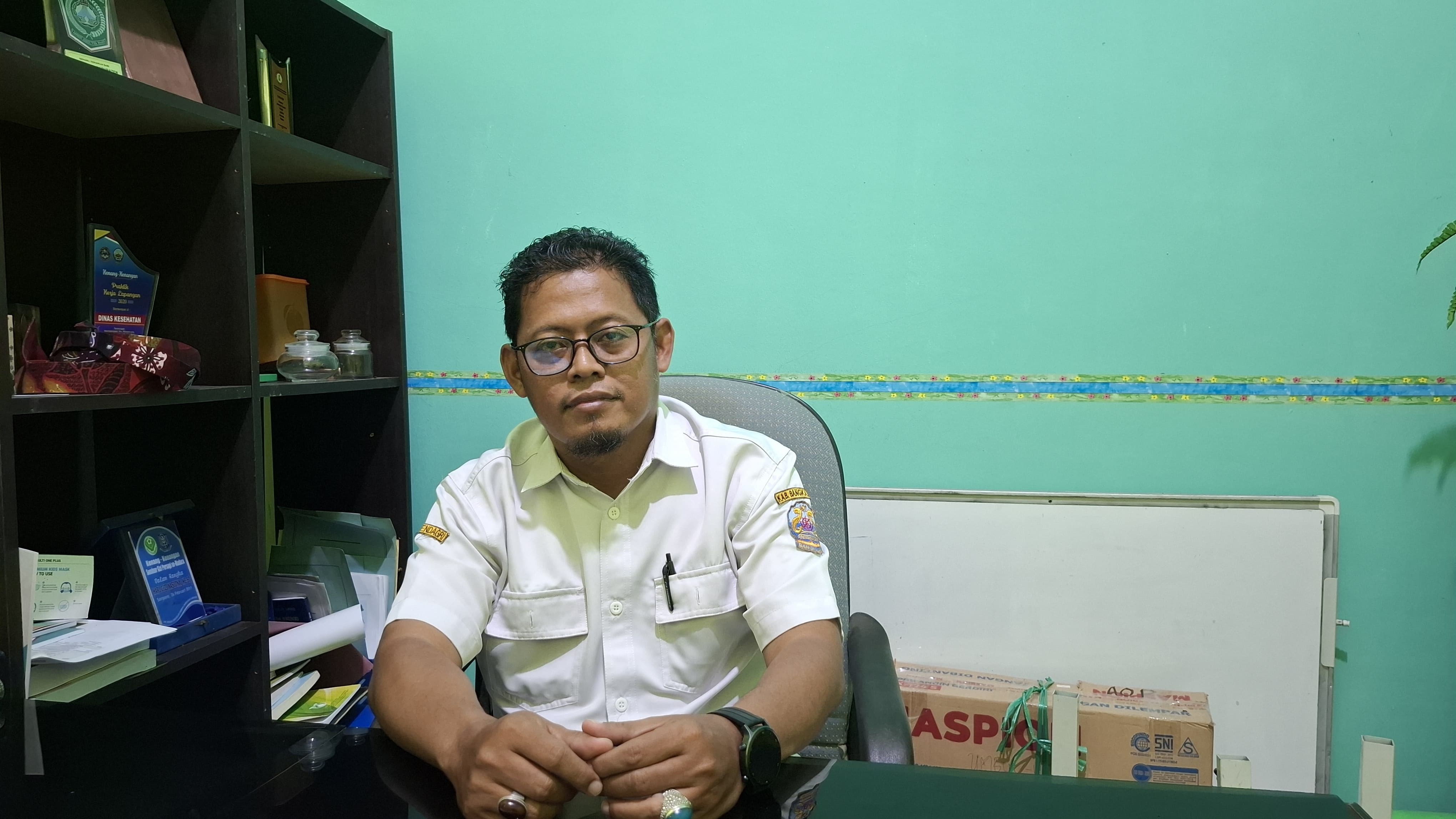 BERI KETERANGAN: Kabid Kesmas Dinkes Bangkalan Aris Budiarto saat ditemui di meja kerjanya, Rabu (26/3). (IMAMUDIN/JPRM)