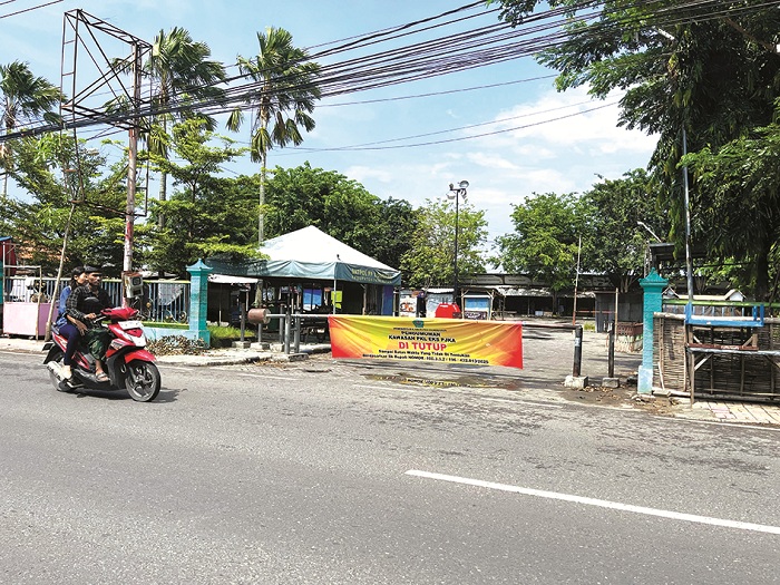 SEPI: Warga melintas di depan pintu eks Stasiun PJKA di Jalan Trunojoyo, Pamekasan, Jumat (4/4). (MOH. IQBAL AFGANI/JPRM)