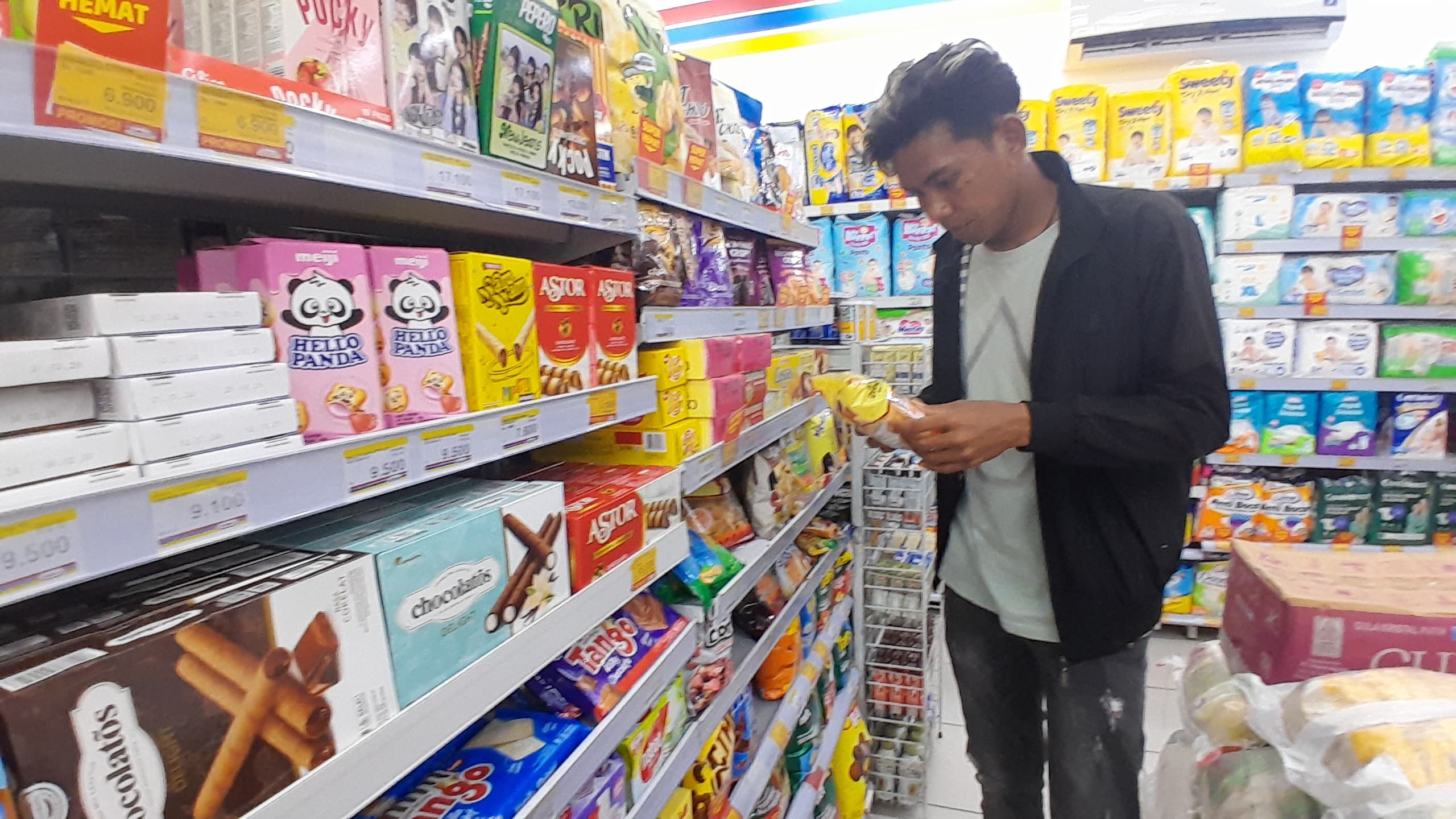 PRODUK LOKAL: Seorang pembeli melihak produk UMKM yang terpajang di rak toko modern di Jalan Kabupaten, Pamekasan, Minggu (9/2). (M. KHOLIL RAMLI/JPRM)