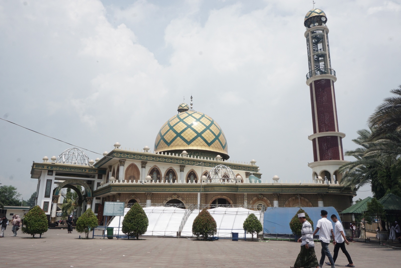 WISATA RELIGI: Peziarah berjalan di dekat tenda haul akbar Syaikhona Muhammad Kholil di Desa Martajasah, Kecamatan Kota Bangkalan, Selasa (8/4). (VIVIN AGUSTIN HARTONO/JPRM)