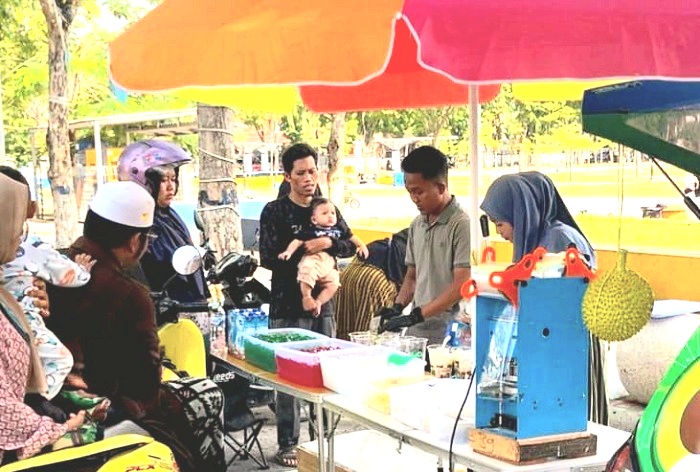 PRODUKTIF: Warga Desa Torjunan, Kecamatan Robotal, Fathurrosyid (kaus abu-abu) berjualan di sekitar Alun-Alun Trunojoyo, Kota Sampang, Kamis (27/3). (FATHURROSYID UNTUK JPRM)