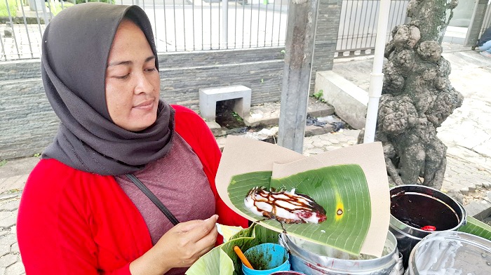 JAJANAN TRADISIONAL: Kholilah menunjukkan tajin sobih buatannya di Jalan Trunojoyo, Bangkalan, Sabtu (5/4). (IMAMUDIN/JPRM)