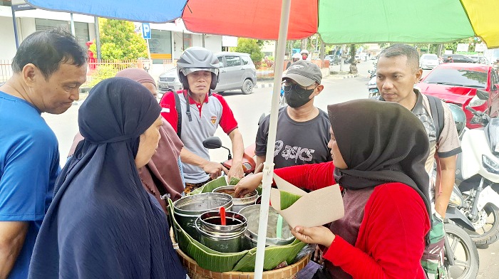 RAMAI: Kholilah melayani pembeli di Jalan Trunojoyo, Bangkalan, Sabtu (5/4). (IMAMUDIN/JPRM)