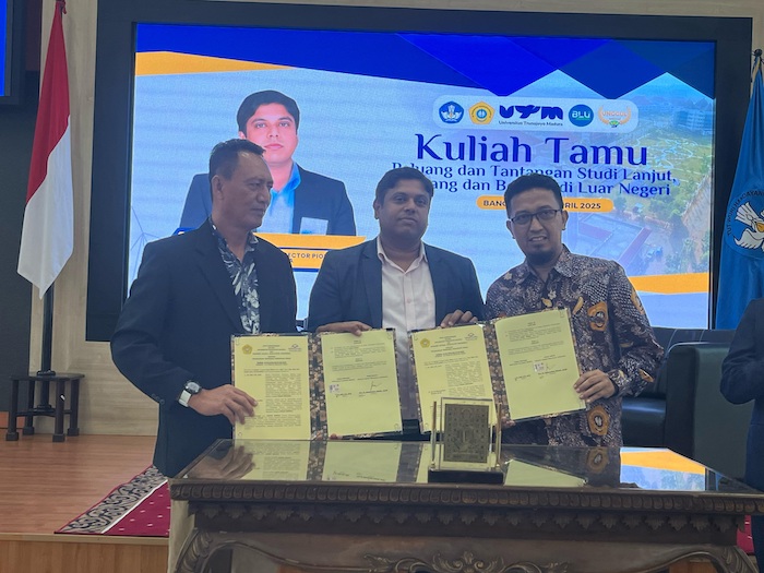 KERJA SAMA: Wakil Rektor Bidang Akademik UTM Achmad Amzeri (kanan) bersama Director-Ceo and Executive Director PGA Australia Amar N Rai (tengah) memperlihatkan naskah MoU yang baru ditandatangani.
