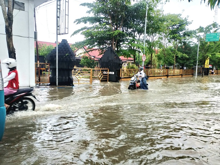 KEBANJIRAN: Pengendara sepeda motor menerobos genangan air di Jalan Jamaluddin, Sampang, Selasa (15/4). (UBAIDILLAHIR RAIE/JPRM)
