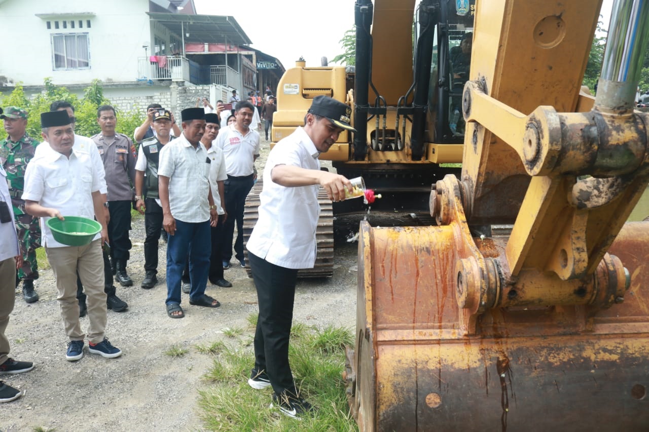 SEMOGA LANCAR: Bupati Bangkalan Lukman Hakim didampingi wakilnya, Moch Fauzan Jafar menyiram air bunga ke alat berat yang digunakan untuk normalisasi DAS Tunjung, Kecamatan Burneh, Rabu (16/4).