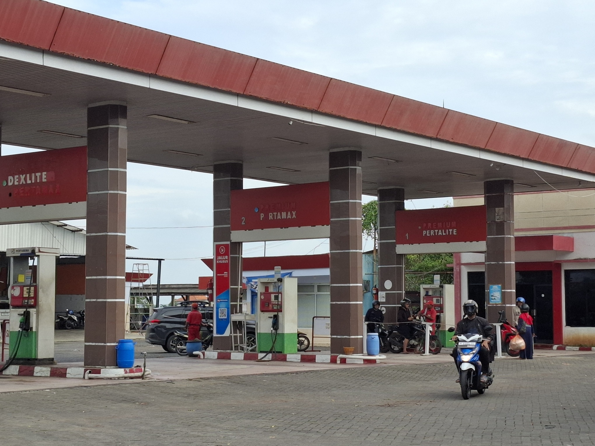 UNIT USAHA: Pengendara sepeda motor mengisi BBM di SPBU Pertamina 54.694.08 yang merupakan salah satu unit usaha PT WUS di Jalan Arya Wiraraja, Gedungan, Sumenep, Minggu (23/3). (MOH. LATIF/JPRM)