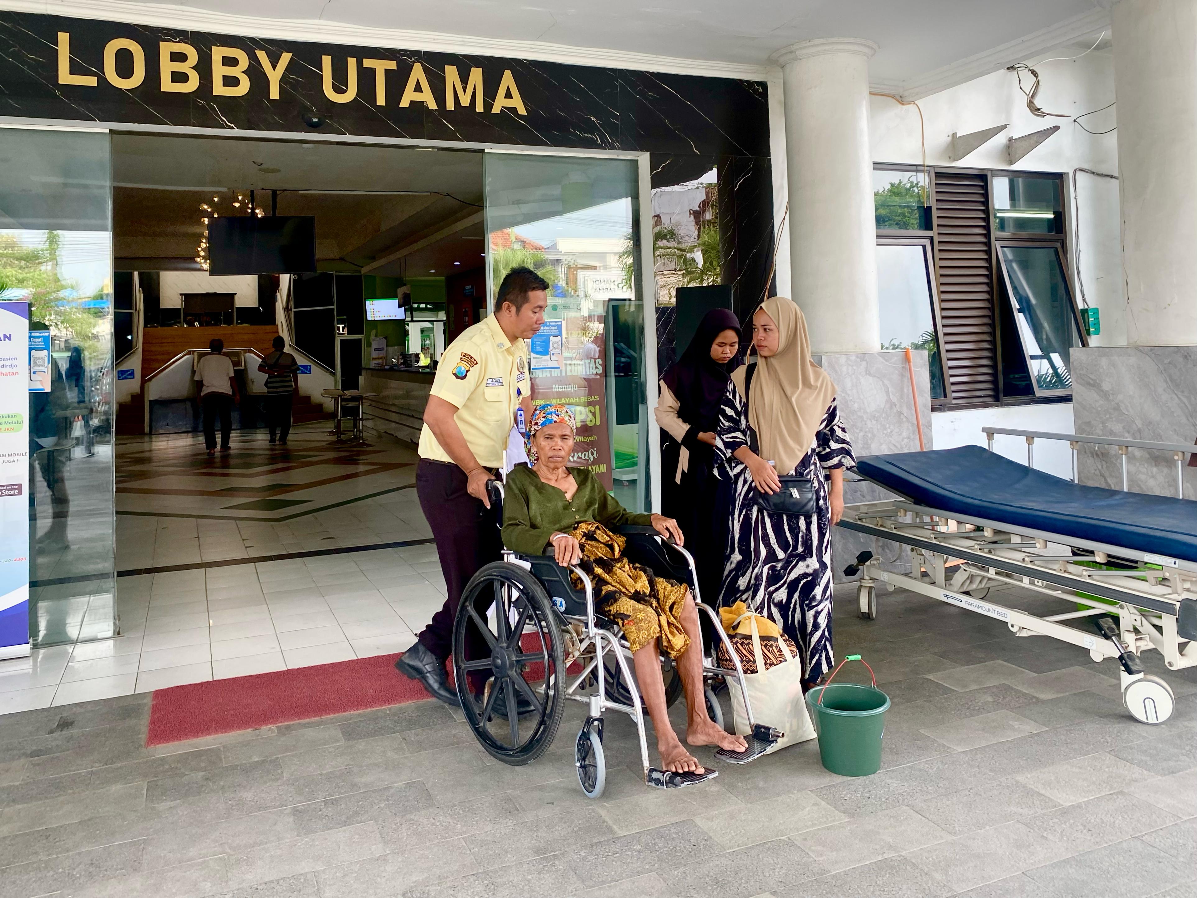 SEPENUH HATI: Petugas keamanan membantu pasien di depan lobi RSUD Smart Pamekasan, Kamis (18/4). (FAHMI JALIL/JPRM).