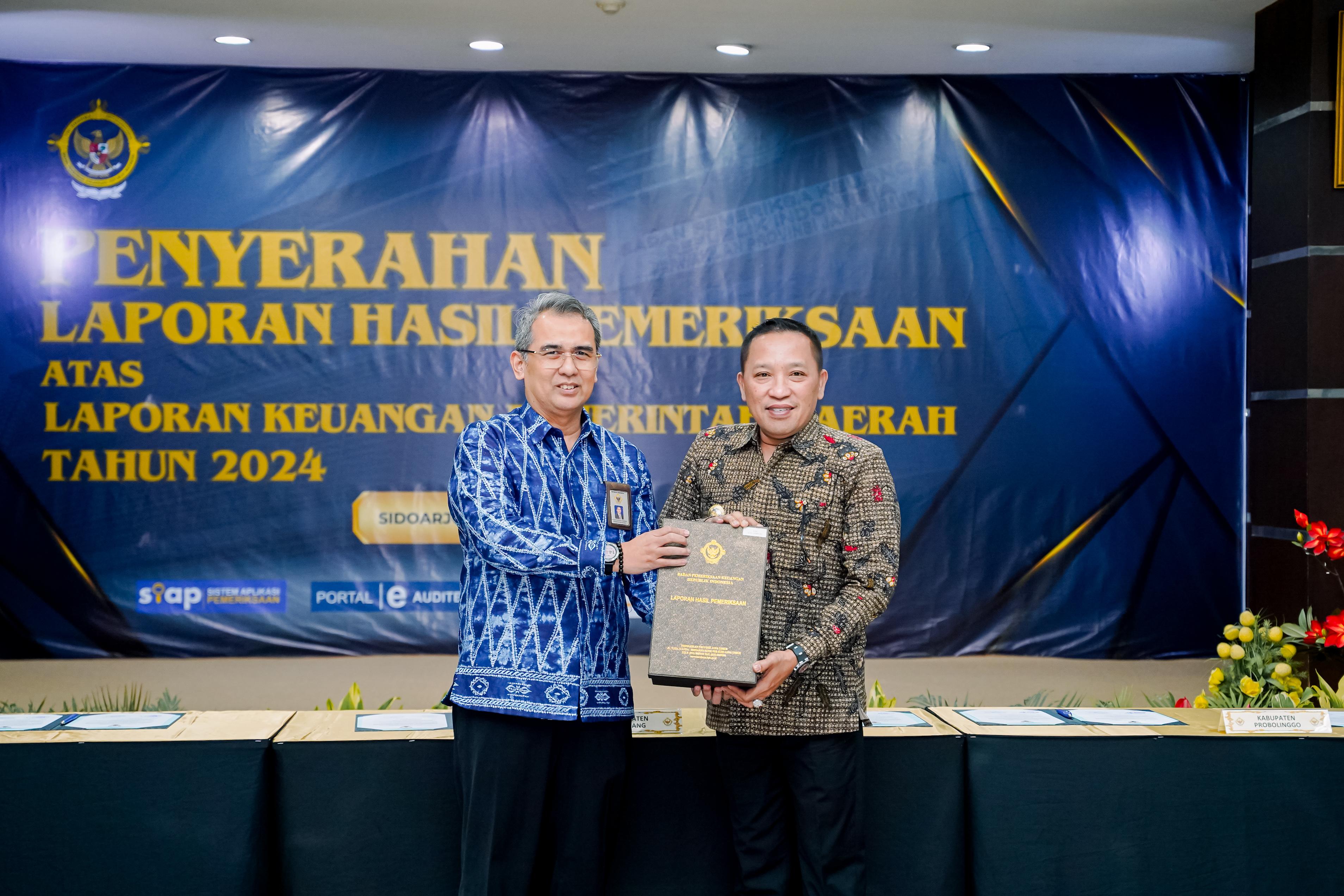BERWIBAWA: Bupati Sampang Slamet Junaidi menerima laporan hasil pemeriksaan BPK RI dari Kepala BPK Perwakilan Jatim Yuan Candra Djaisin di kantor BPK Perwakilan Jatim di Sidoarjo. (PROKOPIM SAMPANG)