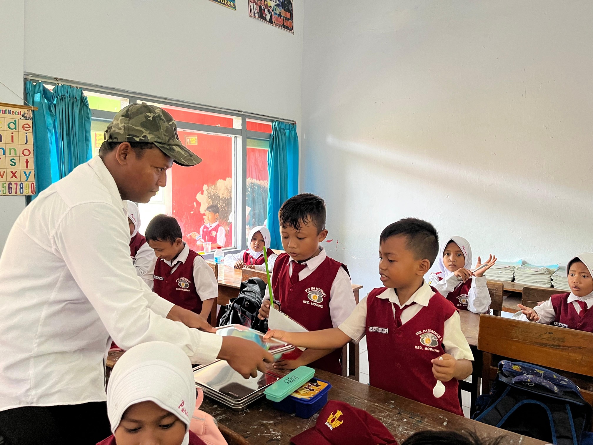 SEHAT: Siswa SDN Patereman 1, Kecamatan Modung, Bangkalan, menerima MBG, Kamis (9/1). (ZEINAL ABIDIN/JPRM)
