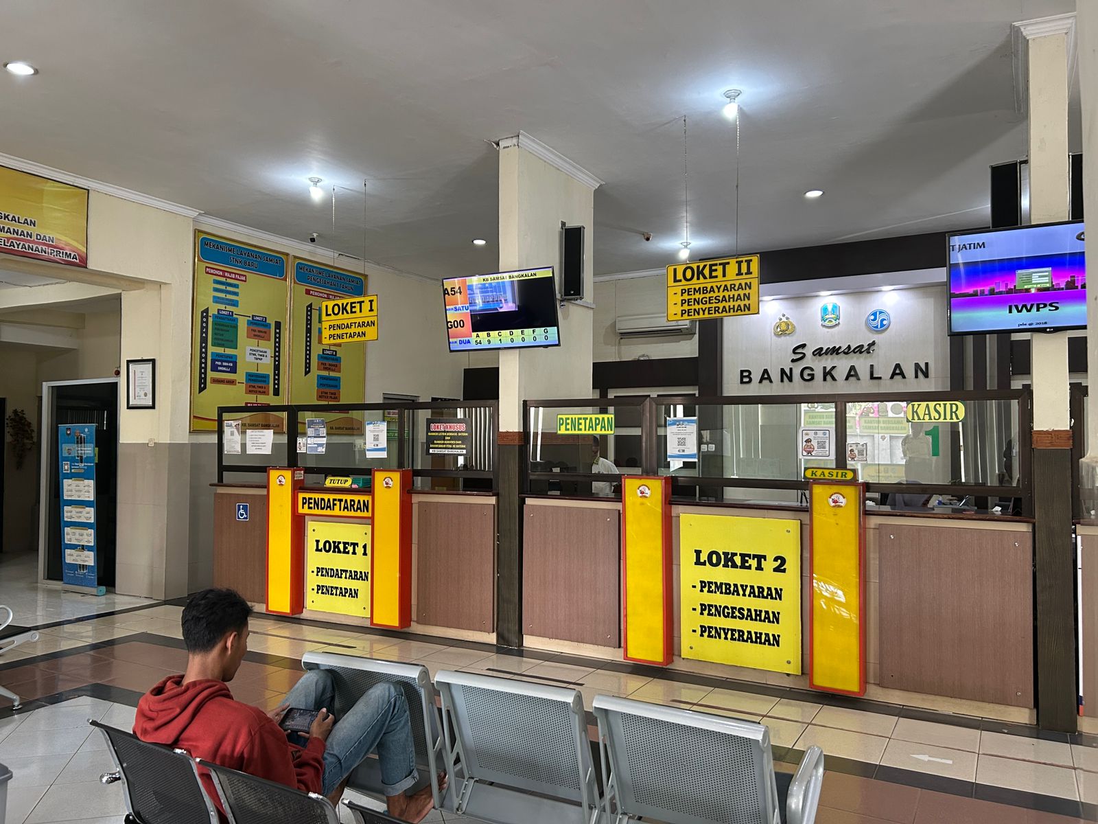 BPKB ELEKTRONIK: Masyarakat wajib pajak sedang duduk di ruang tunggu di KB Samsat Bangkalan yang terletak di Jalan Soekarno-Hatta, Nomor 12, Bangkalan, Kamis (9/1). (VIVIN AGUSTIN HARTONO/JPRM)