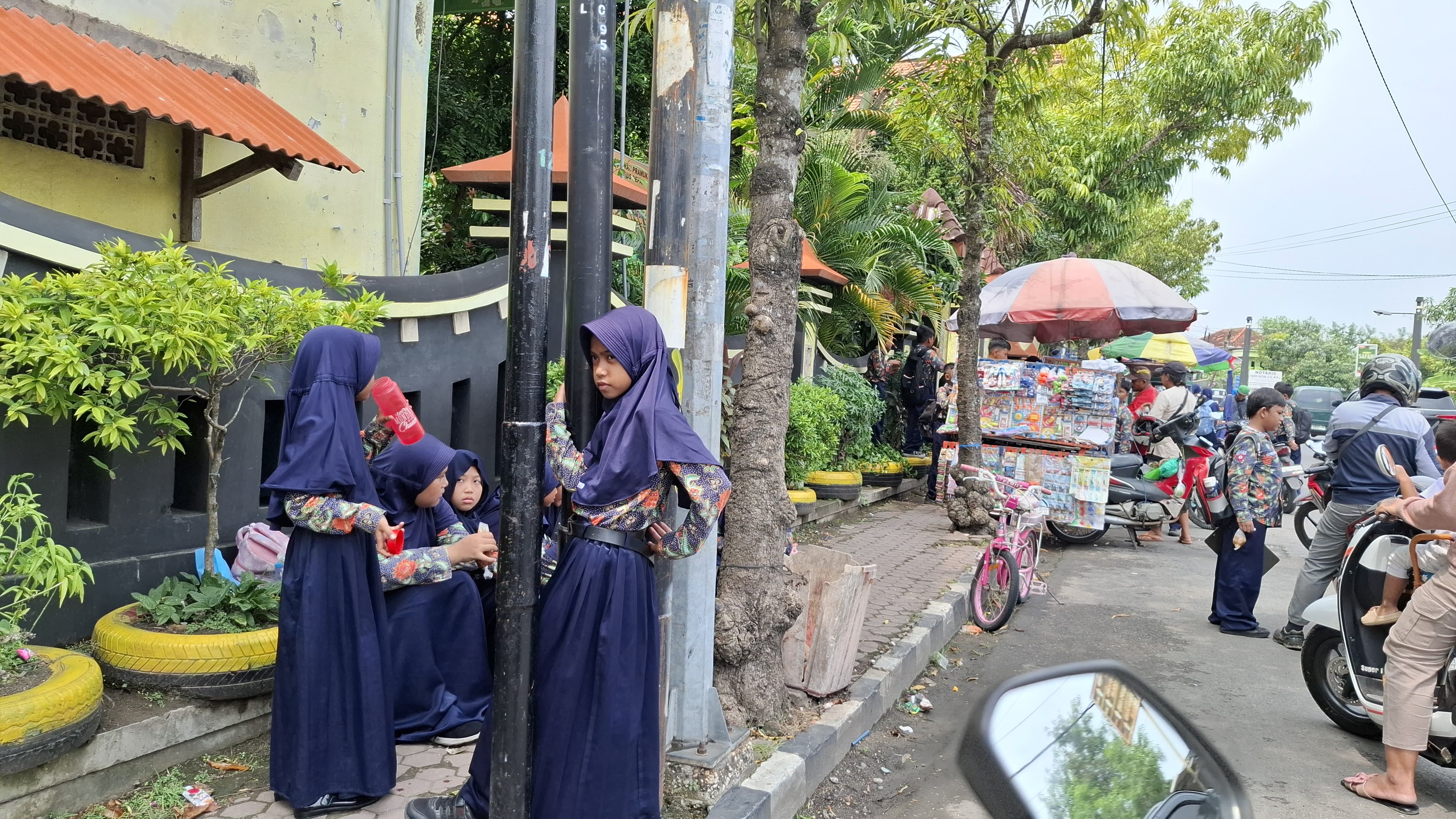 JAM PULANG: Siswa SDN Kraton 3, Bangkalan, menunggu jemputan di depan sekolah, Kamis (17/4). (IMAMUDIN/JPRM)