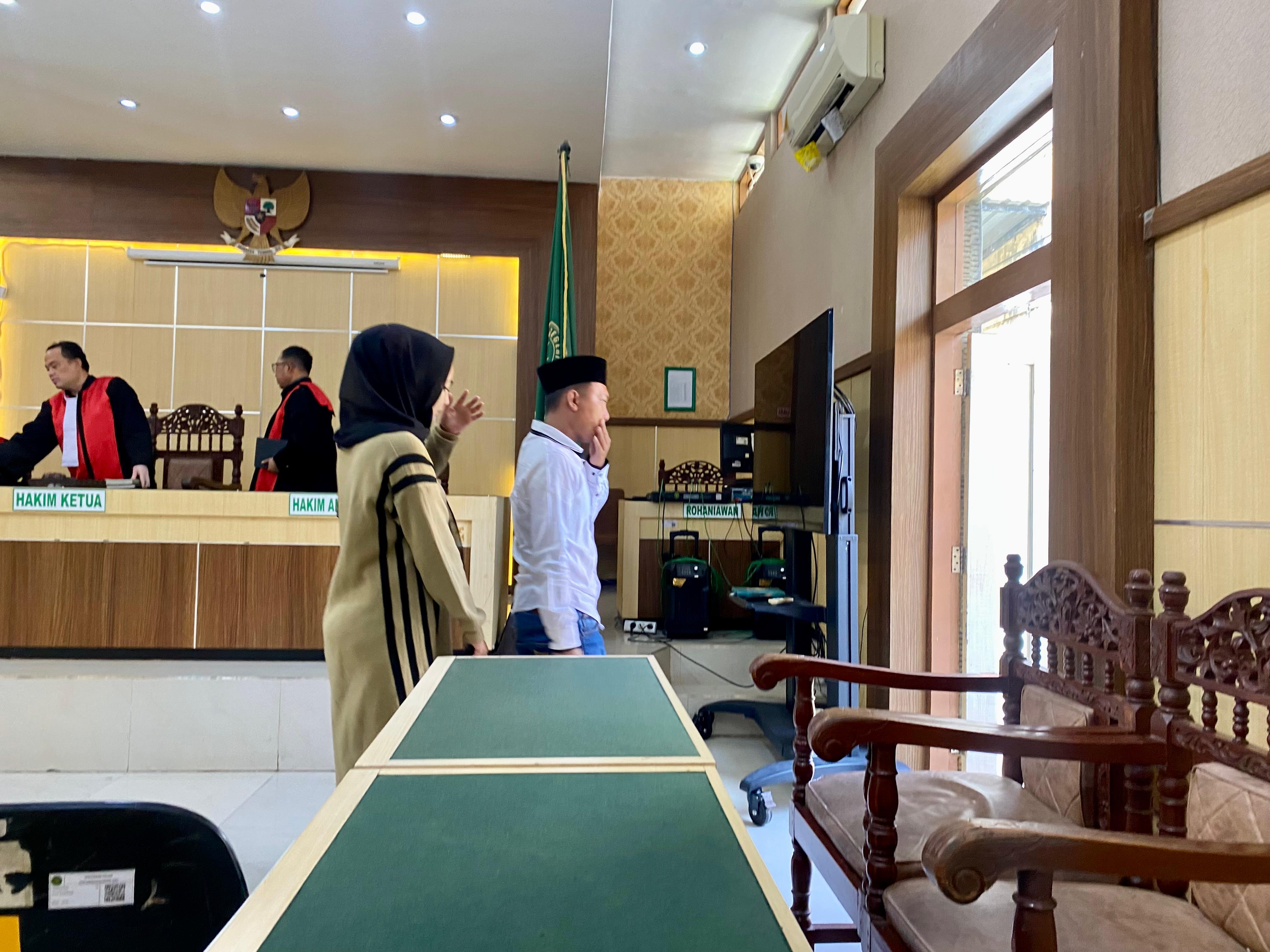 JADI PESAKITAN: Dua terdakwa kasus dugaan penipuan keluar dari ruang sidang PN Pamekasan, Selasa (22/4). (MOH. IQBAL AFGANI/JPRM)